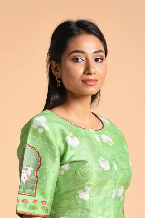 Green coloured Pichwai printed blouse crafted from luxurious raw silk fabric.