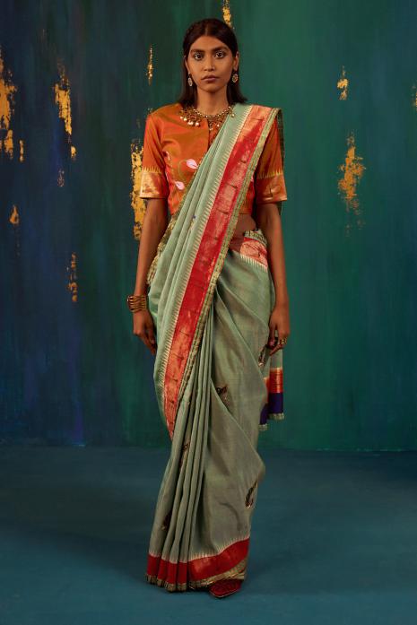 A beautiful fusion handwoven Paithani saree in green colour, with intricate hand-embroidery featuring Pichwai motifs in vibrant colors and exquisite craftsmanship.
