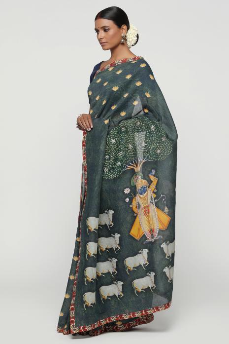 A handwoven tussar linen fabric saree in dark green colour with a beautiful intricate print featuring traditional Pichwai motifs.